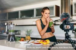 Fit female taking a sip of her fruit juice in front of camera 5zLvPb