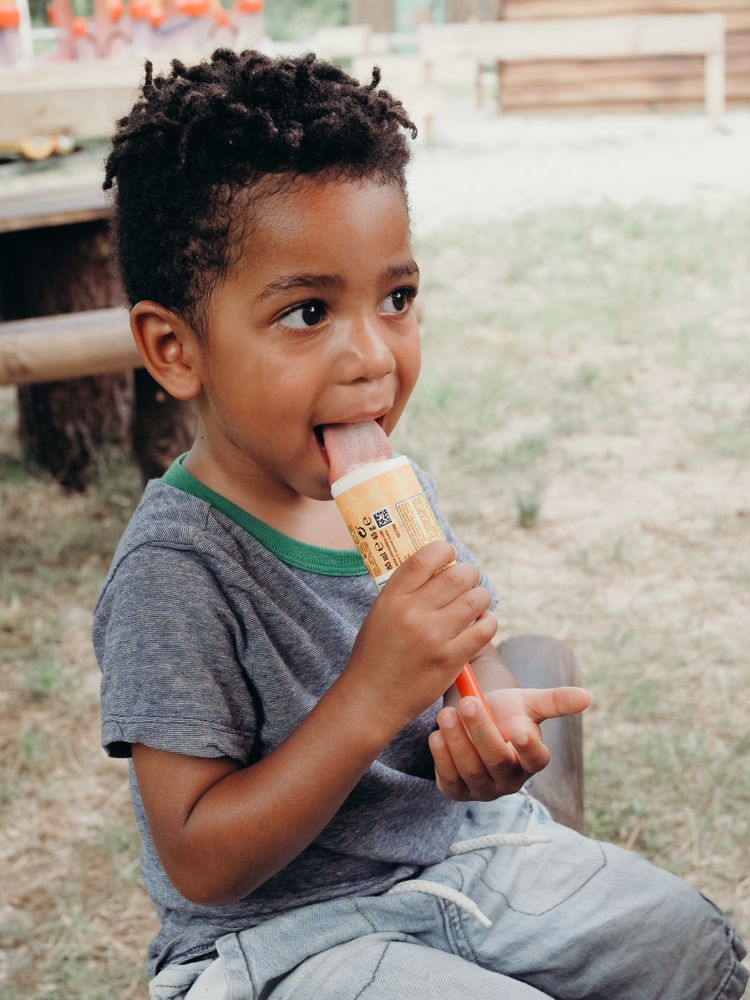 Black child licking ice cream
