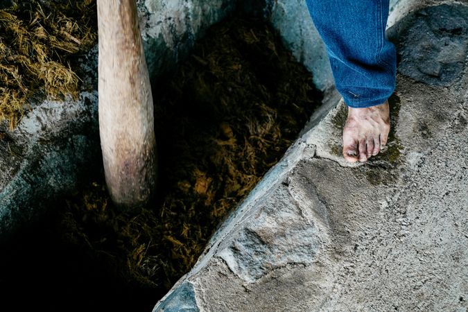 Adult man pressing organic material into cemented ditch