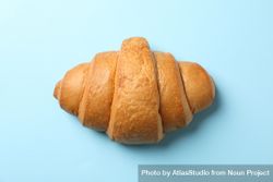 Freshly baked croissant on blue background, top view 42myx5