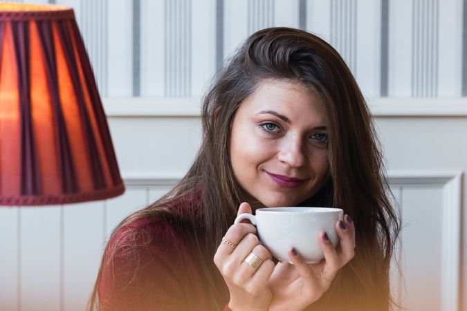 Woman with cup of coffee in cafe