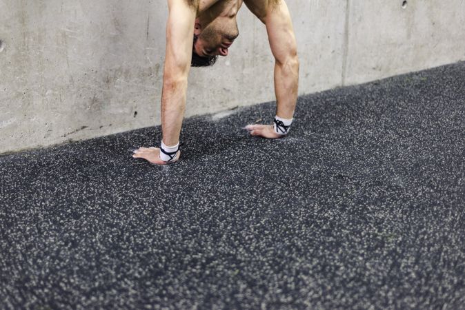 Man doing handstand in gym