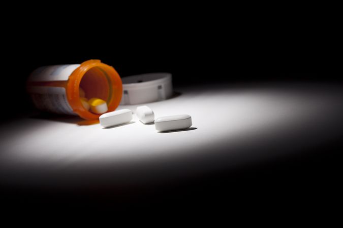 Medicine Bottle and Pills Under Spot Light