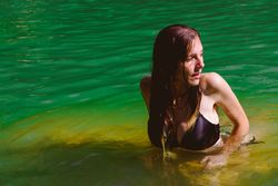 Woman standing in pool and looking away