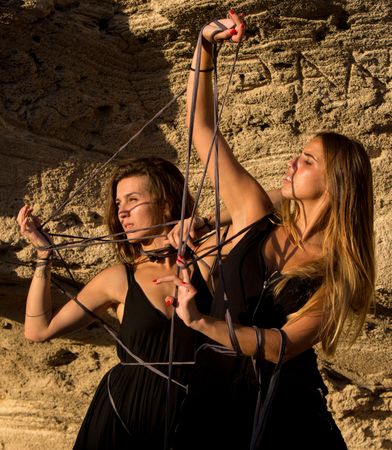 Women with thread posing near stones