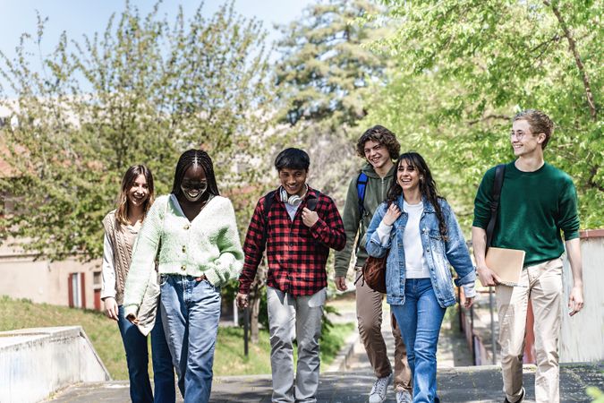 Multi-ethnic group of students walking through campus to class