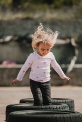 Cute girl jumping on car tires
