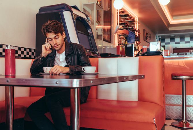 Man sitting in booth of retro diner