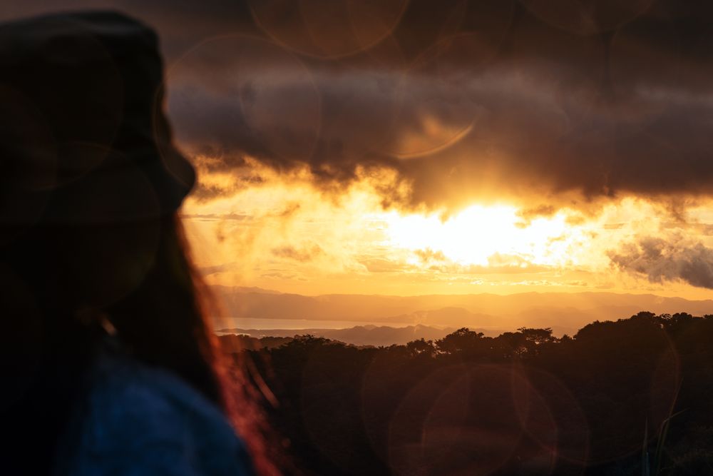 Woman watching the sunset in the countryside in Costa Rica