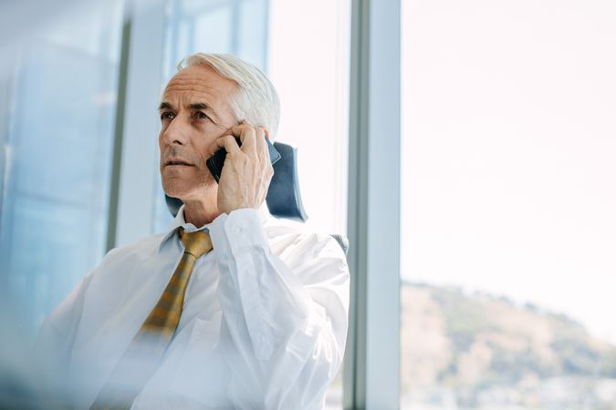 Mature manager using cell phone in office