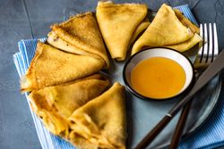 Pancakes served with honey and cutlery