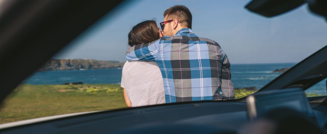 Young couple kissing near the coast