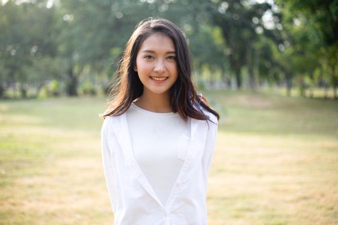 Portrait of smiling Asian woman in public park