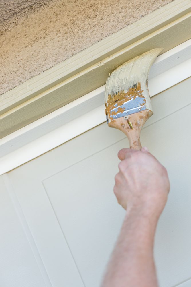 Professional Painter Cutting In With Brush to Paint Garage Door Frame