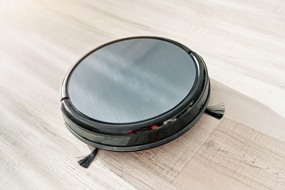 Robotic vacuum cleaner placed on floor in apartment
