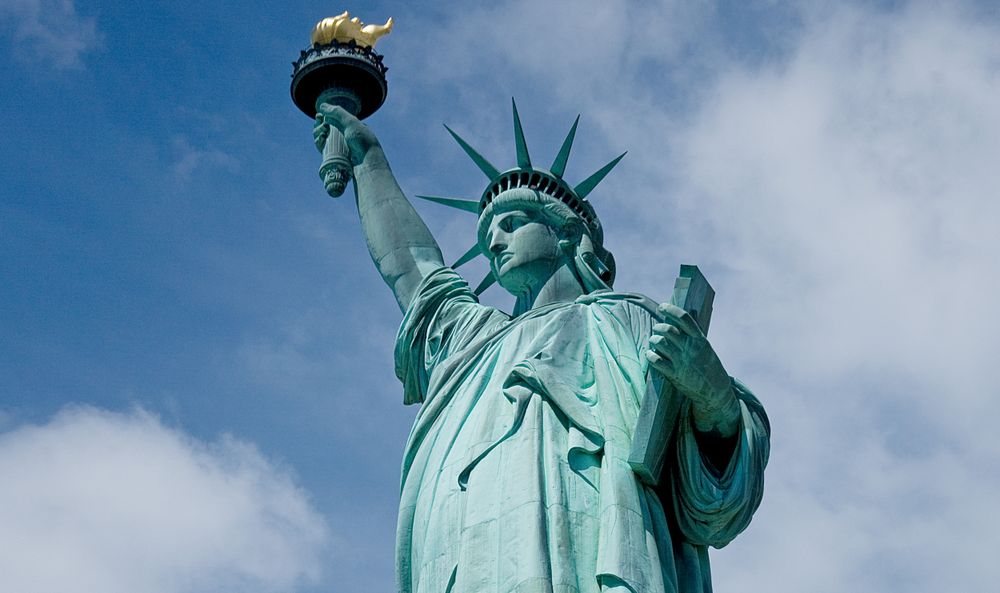 Up shot of Statue of Liberty against a blue sky with clouds, New York City, New York