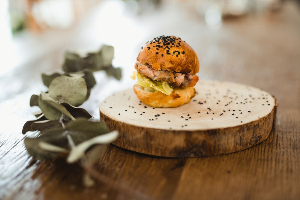 Delicious hamburger with sesame on wooden tray