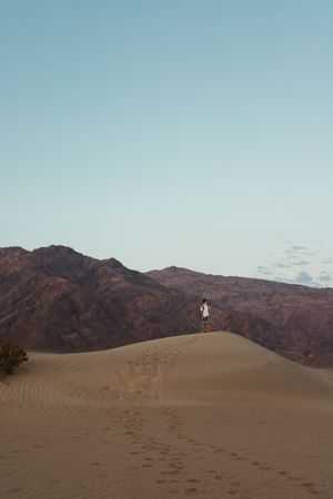 Lonely man walking in sandy desert