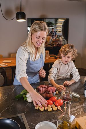 Woman with son taking vegetables from table