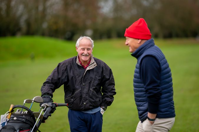 Two men walking on golf course with clubs