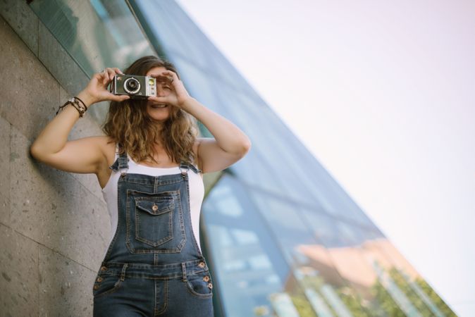 Creative woman taking photo on camera in sunny day