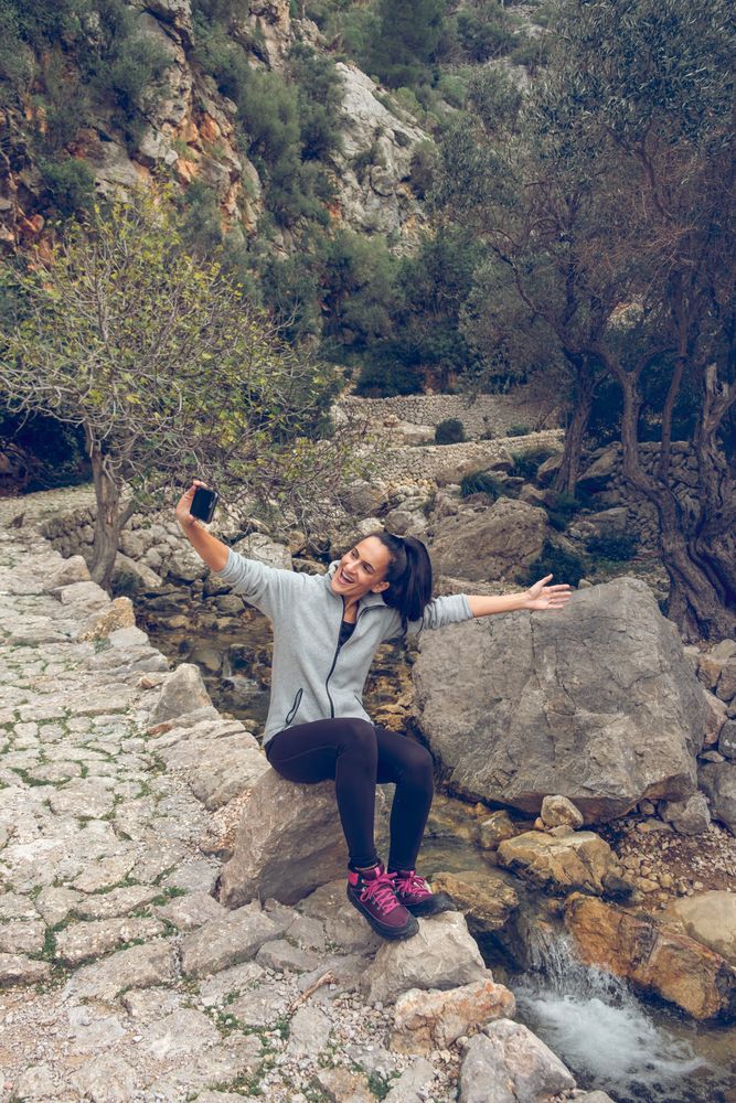 Joyful woman screaming and smiling while taking selfie i