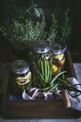 Fresh green vegetables with fruits and glass jars