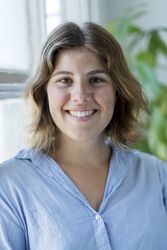 Portrait of happy young woman smiling by window, vertical