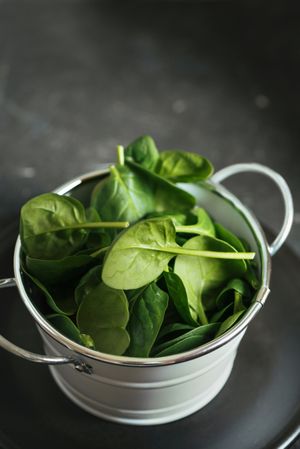 Fresh spinach on a rustic metal crockery bowl