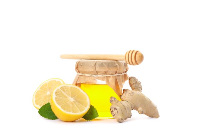 Dipper, lemons, ginger and glass jar with honey isolated on neutral background