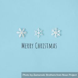Row of snowflakes on blue background with “Merry Christmas” 0VzaN0