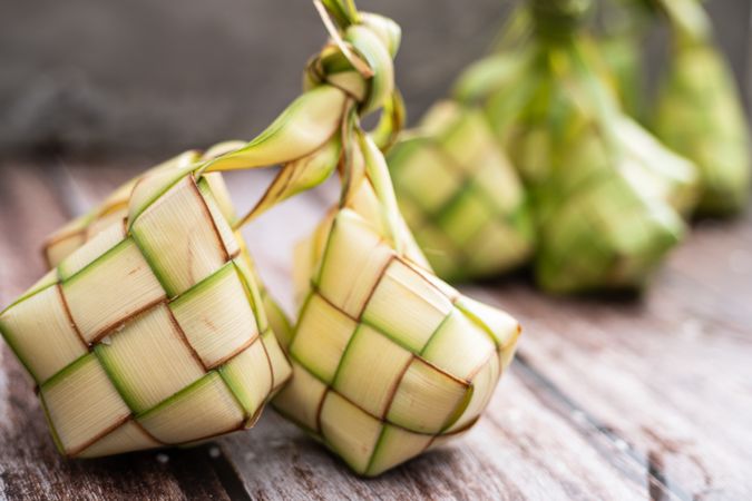 Uncooked ketupat filled with rice, placed on wooden surface