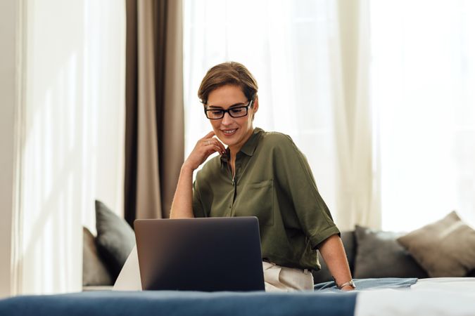 Businesswoman working on her laptop from a modern apartment