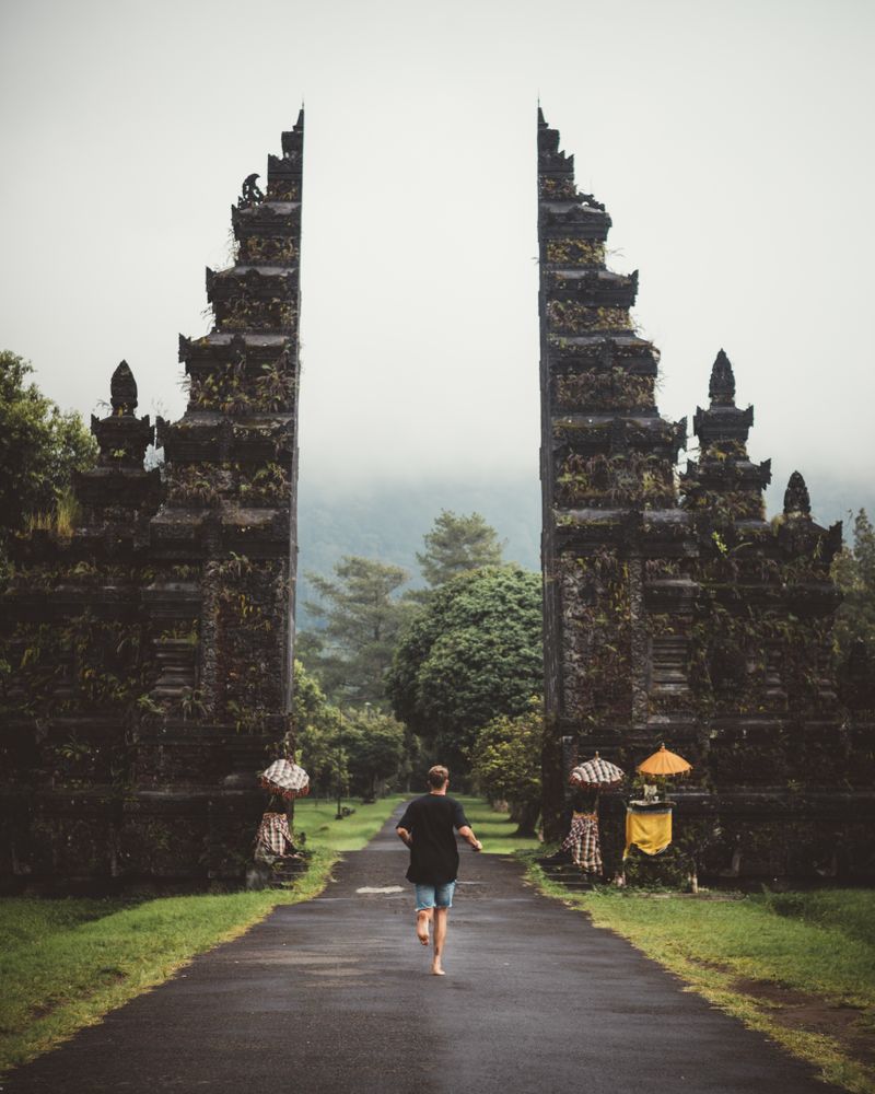 Man running into gates of ancient temple