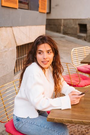 Young woman using smartphone in outdoors cafe