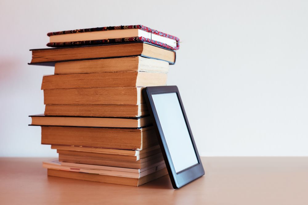 Vintage books next to an e-Book
