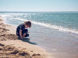 Child playing with sand on beach