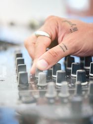 Unrecognizable DJ adjusting sound of disco music
