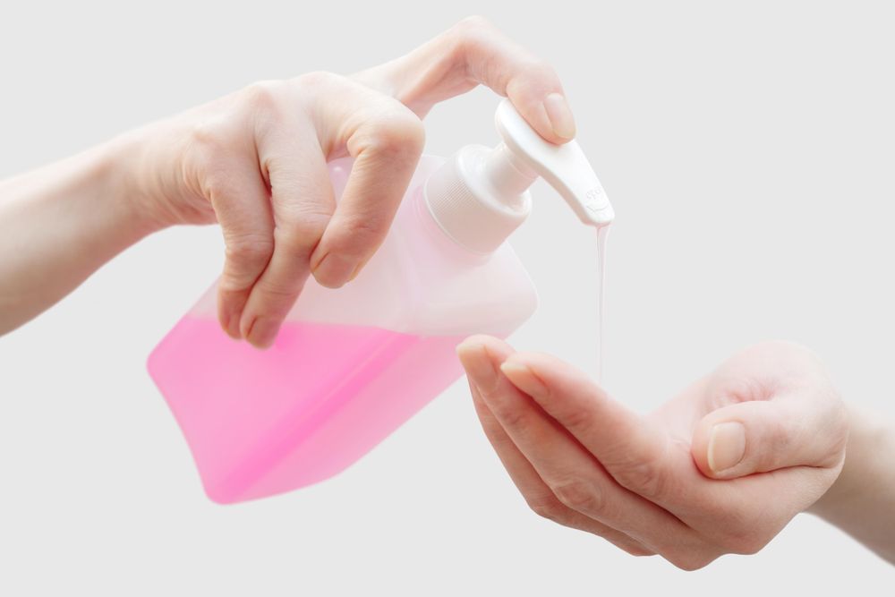 Person putting liquid soap on their hand