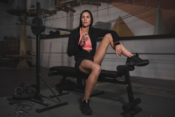 Smiling woman with energy bar in gym