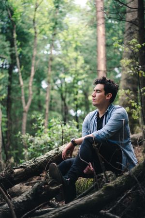 Man sitting on tree log in nature