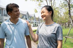 Male and female chatting on walkway in residential area