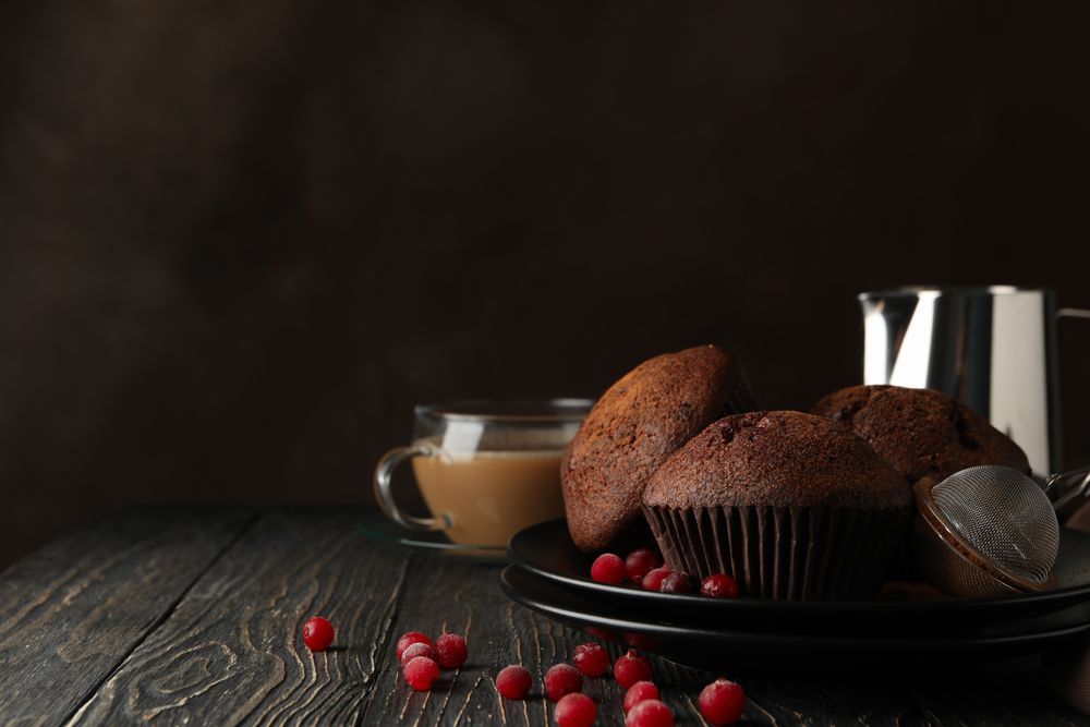 Composition with tasty muffins and cocoa drink on wooden background