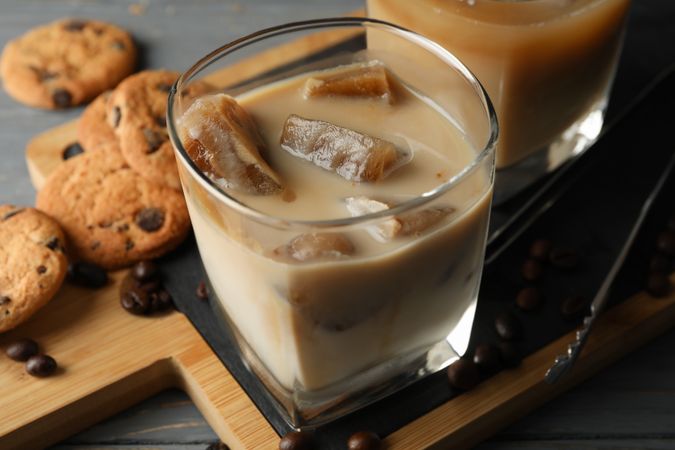Composition with ice coffee and cookies on wooden background