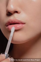 Cropped shot of woman applying lip glass to her lips 56vLe5