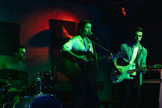 Musicians In Stage With Colorful Lights Performing In A Live Concert