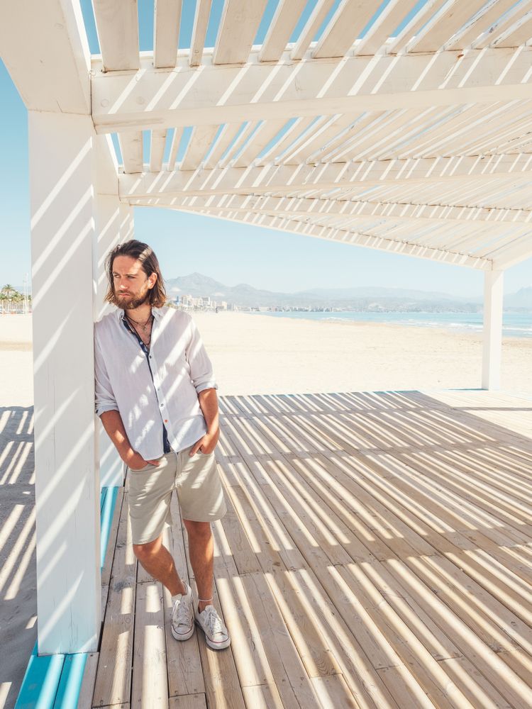 Relaxed man standing in gazebo on beach