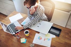 Top view of woman taking phone in home office with coffee