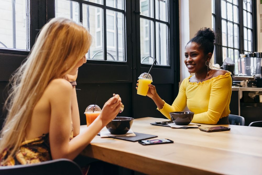 Two friends talking over lunch at cafe