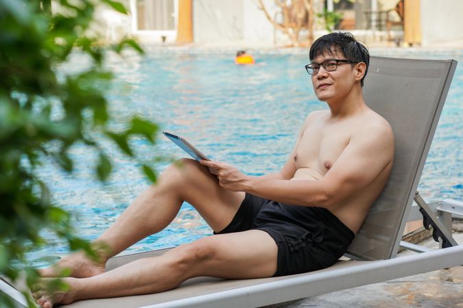 Man working remotely by poolside